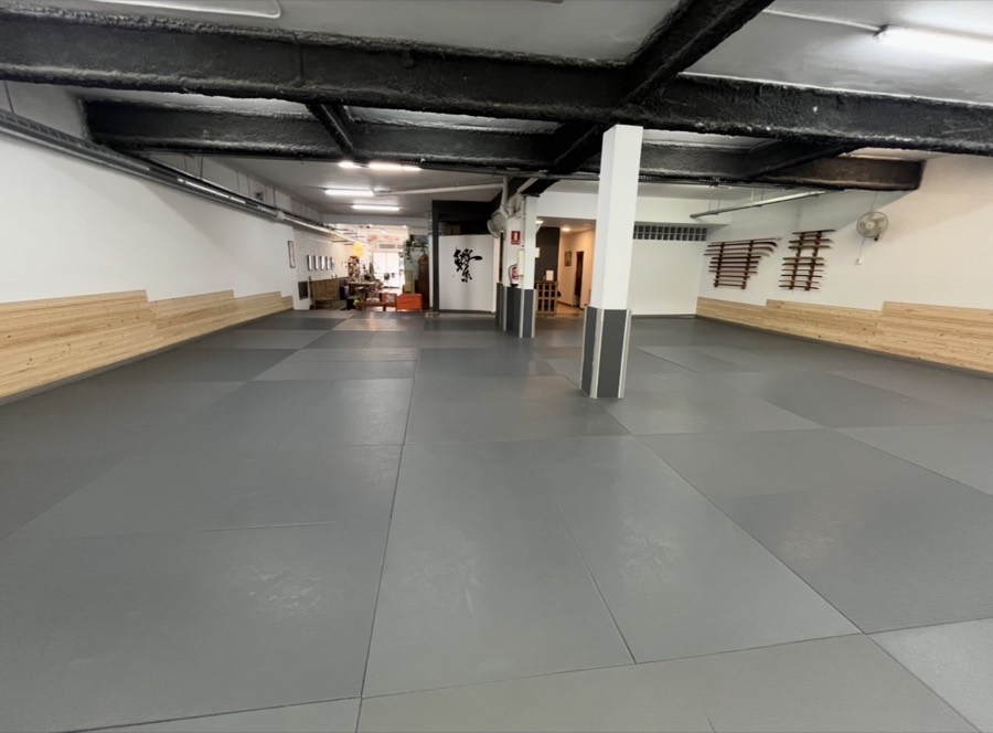 Sala de tatami del Dōjō Feilen Meishūkan, amb tatami gris i armes a la paret
